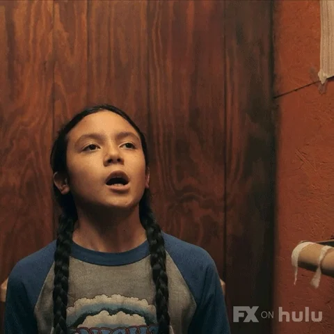 A character from Reservation Dogs in a bathroom stall saying, 