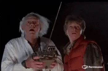 Doc Brown and Marty McFly in Back to the Future. Doc Brown looks at a transmitter that says, 