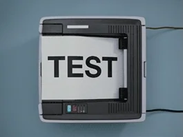 A printer printing the word "Test" on white paper over and over.
