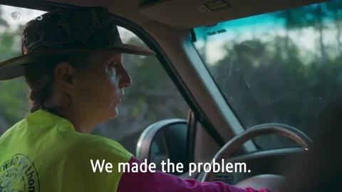 A woman driving and saying: “We made the problem. We gotta fix it.”