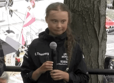 Greta Thunberg passing a microphone away from her