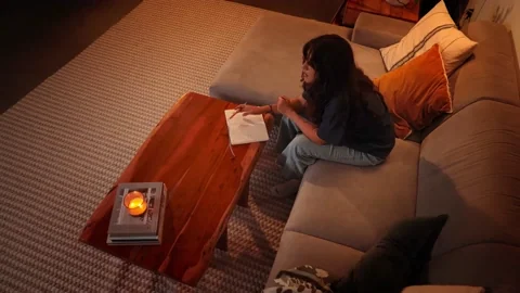 A girl thinks as she prepares to write in her journal.