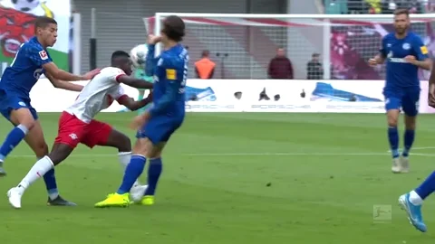 A soccer player collapses after being tackled by an opponent.