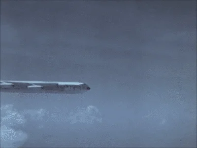 Documentary footage of a bomber plane dropping a nuclear weapon.