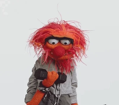 Animal from The Muppets lifts weights.