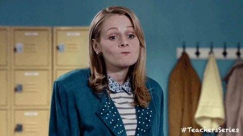 A teacher nodding in agreement with a slight side smirk and clenched lips. 
