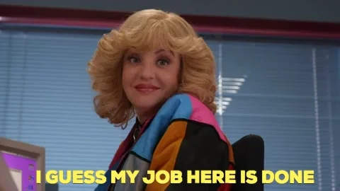 A blonde woman in multicolored jacket shrugging her shoulder sitting in front of a computer saying, 'My job here is done.'