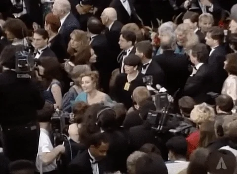 Emma Thompson puts her hand by her ear while struggling to hear a reporter at The Academy Awards.