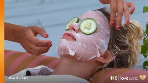 A woman with a face mask is relaxing while taking a massage