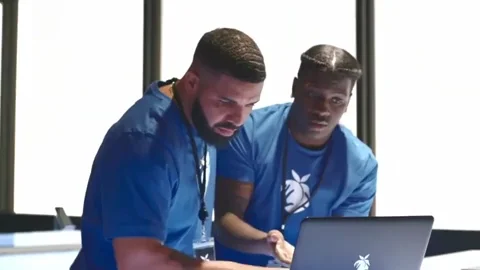 Drake shows something on a laptop to help out Lil Yachty, who then realizes his mistake.