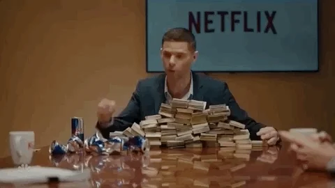 GIF of a man with a pile of stacks of money saying 'here's money! go!'