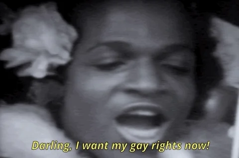 Black and white clip of Marsha P Johnson in front of a microphone, saying 'I want my gay rights now!'