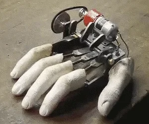 A robotic hand on a desk moving four fingers, showing its motor and mechanical linkages.