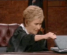 Judge Judy looks at a laptop screen.