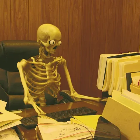 A skeleton typing on a keyboard while applying for jobs. The skeleton collapses from exhaustion.