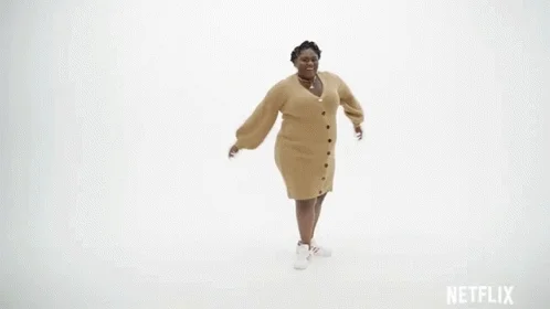 A pregnant woman in office clothing dancing in a studio