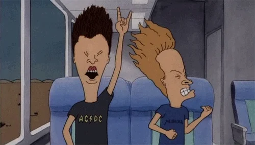 Beavis and Butthead rocking out in the back of a tour bus.