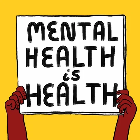 A person holding up a sign that says, 'Mental health is health'.