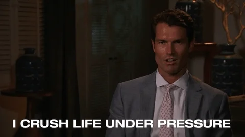 A man in a suit and tie saying, 'I crush life under pressure.'