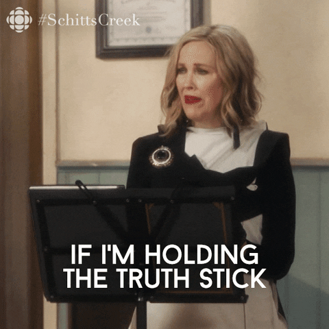 Gif of a woman standing at a podium bashfully saying, &apos;If I'm holding the truth stick.&apos; The word truth is highlighted.