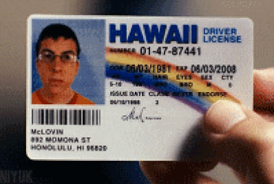 A hand holds the McLovin drivers license from the comedy movie Superbad. 