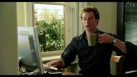 Jim Carey typing quickly on keyboard while drinking coffee
