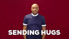 Man hugging self overlaid with the words 'Sending hugs'