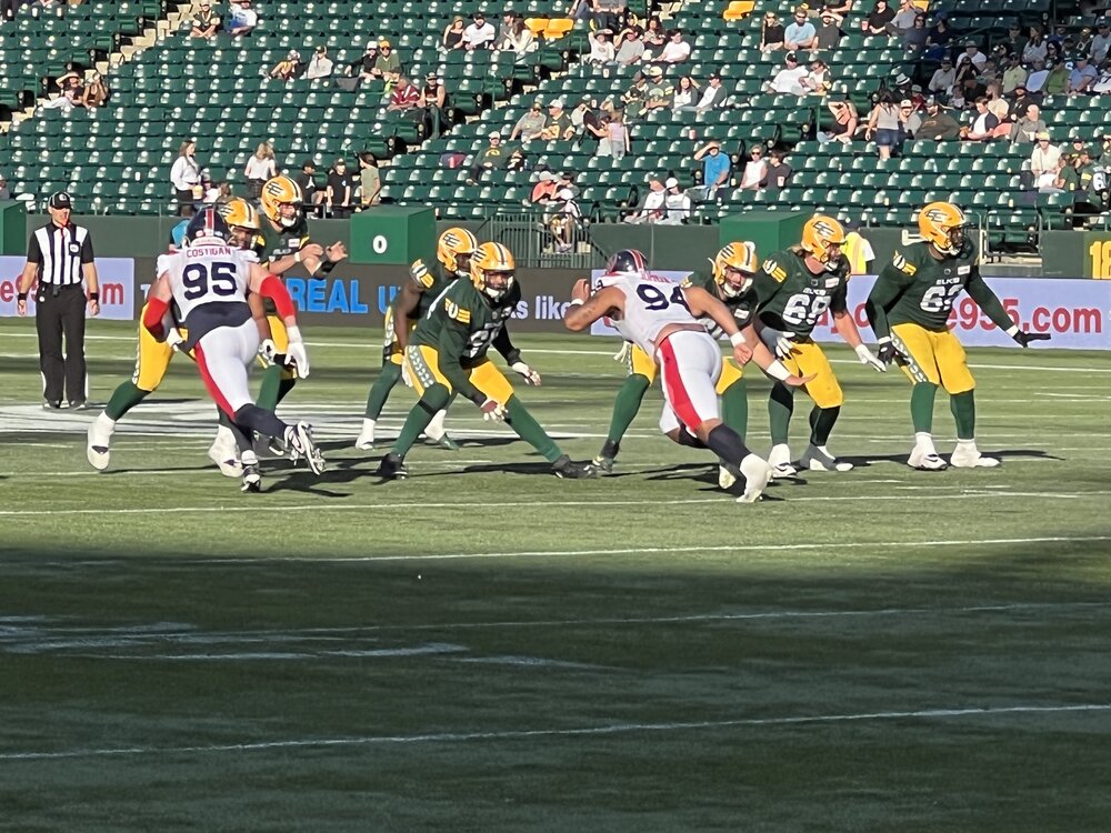 Le quart-arrière des Elks d'Edmonton, Taylor Cornelius, reçoit une remise (snap). Crédit : Isaac Lamoureux