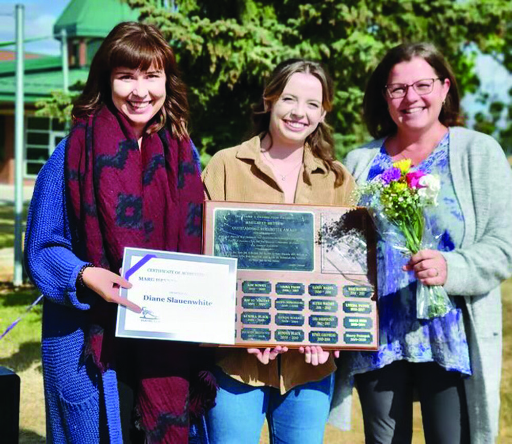 Diane Slauenwhite (à droite, avec les fleurs) a reçu le prix de la bénévole de l'année pour le Figure 8 Skating Club. Justine Toppin (à gauche) et Cassidy Connell (au milieu) sont coordinatrices du programme CanSkate. Crédit : Courtoisie