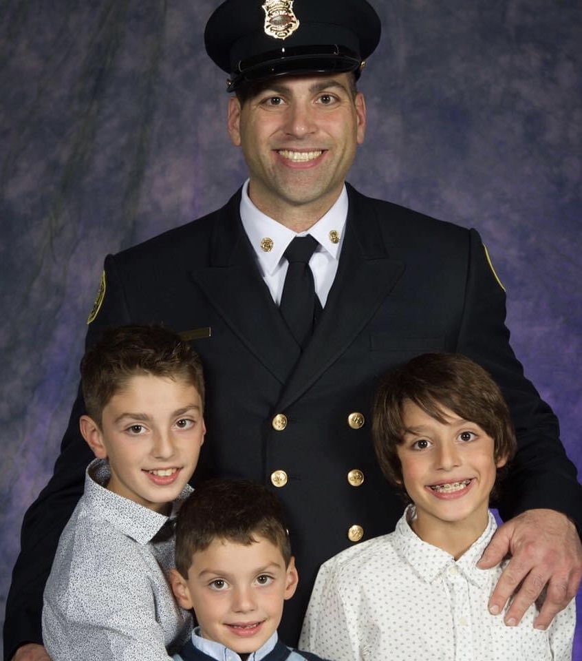 Randy Chevrier en uniforme et ses trois fils. Crédit : Courtoisie