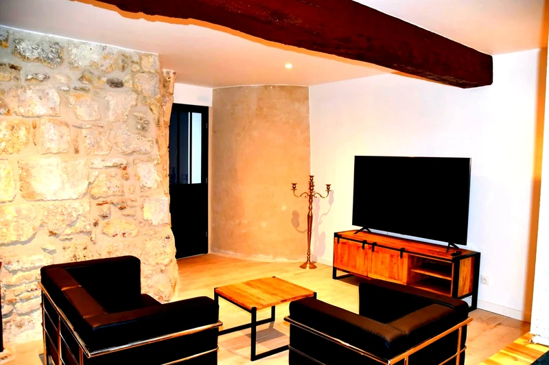 Le salon confortable avec mur en pierre et TV aux Écrins de Laon