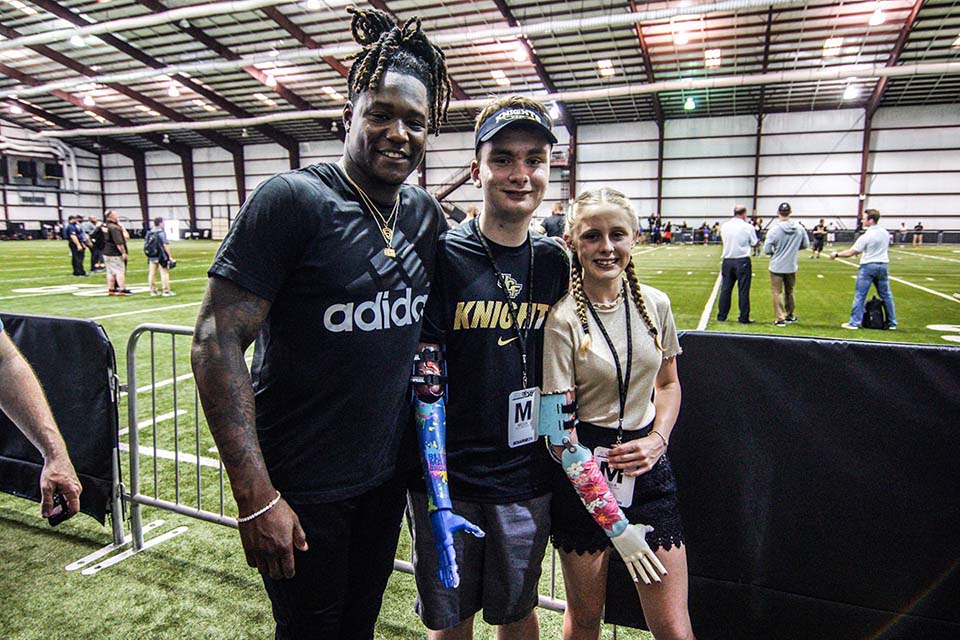 Bionic kids Anni and Wyattt posing with UCF football star Shaquem Griffin