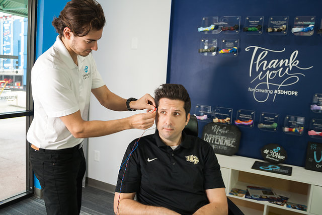 Limbitless intern Juan setting up the project xavier EMG-powered wheelchair on Matt - a professor at Limbitless.