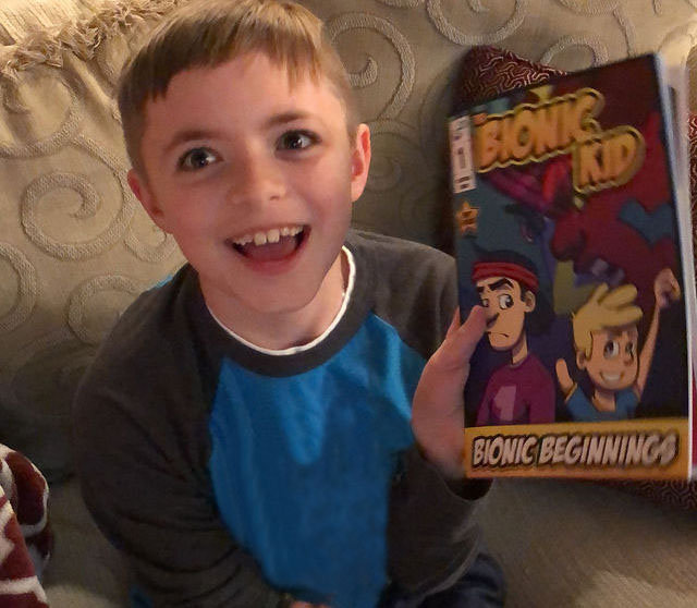 Bionic kid Zac showing off his comic The Bionic Kid.