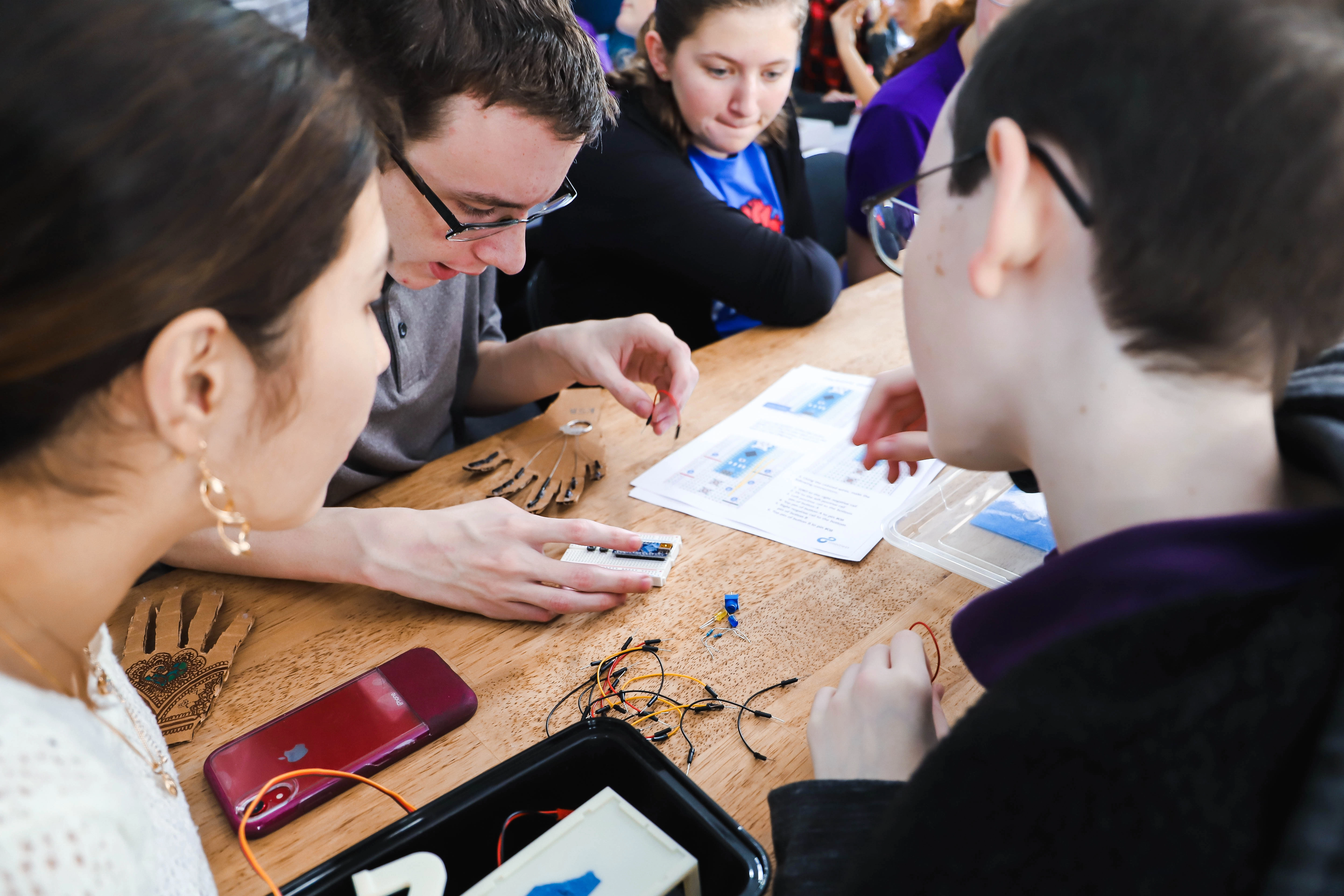 A limbitless intern demonstrating the EMG technology to student visitors