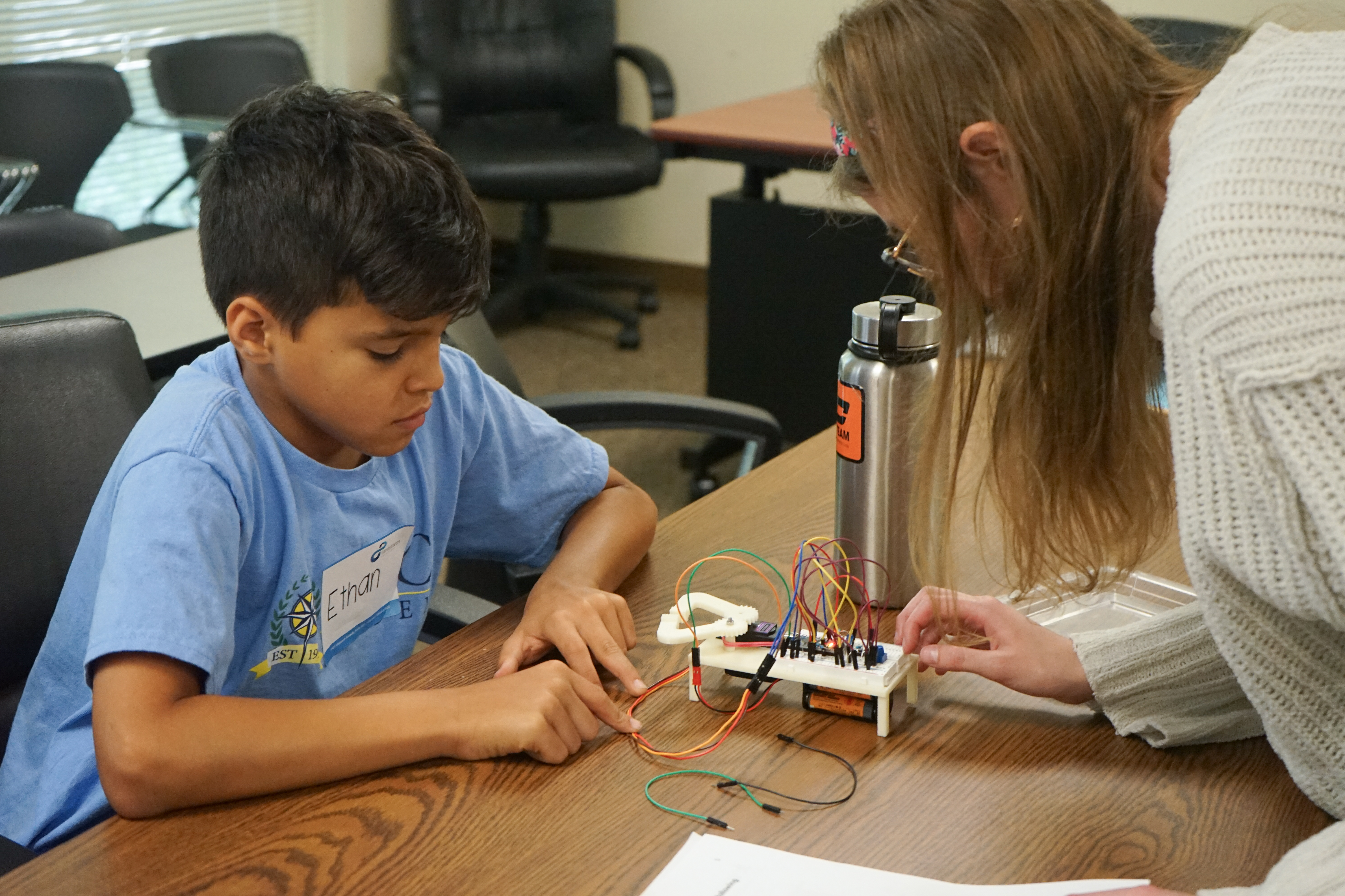 Limbitless employee assisting a student with a project