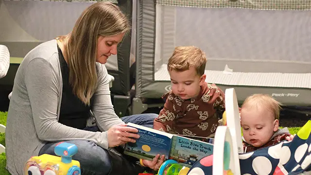 A picture of a kid's worker helping kids learn and have fun.