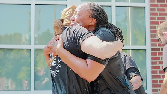 People hugging after a baptism event at The Local Vineyard Church in Midlothian, VA