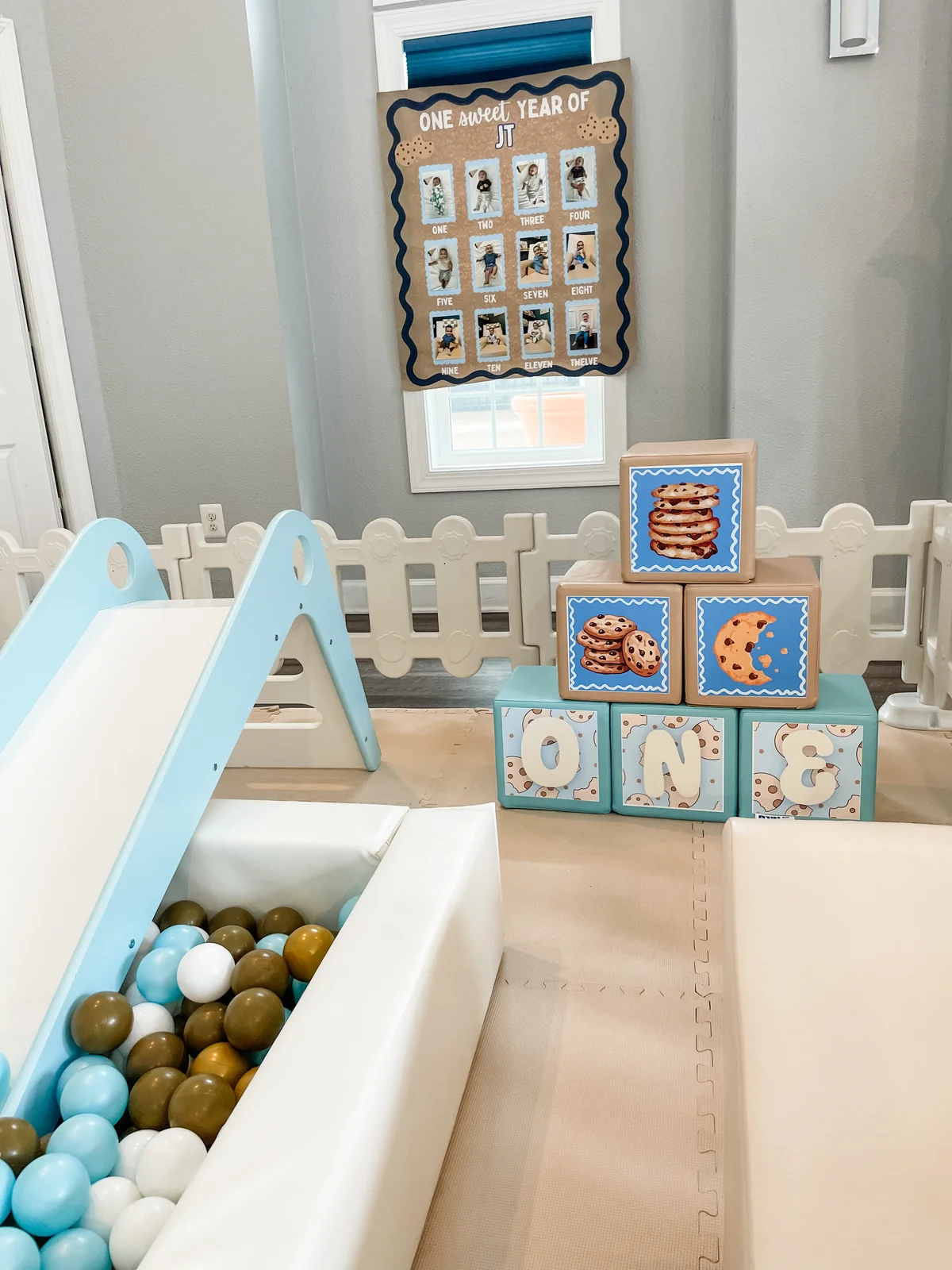 Indoor cookie-themed first birthday soft play with blue ball pit and letter blocks