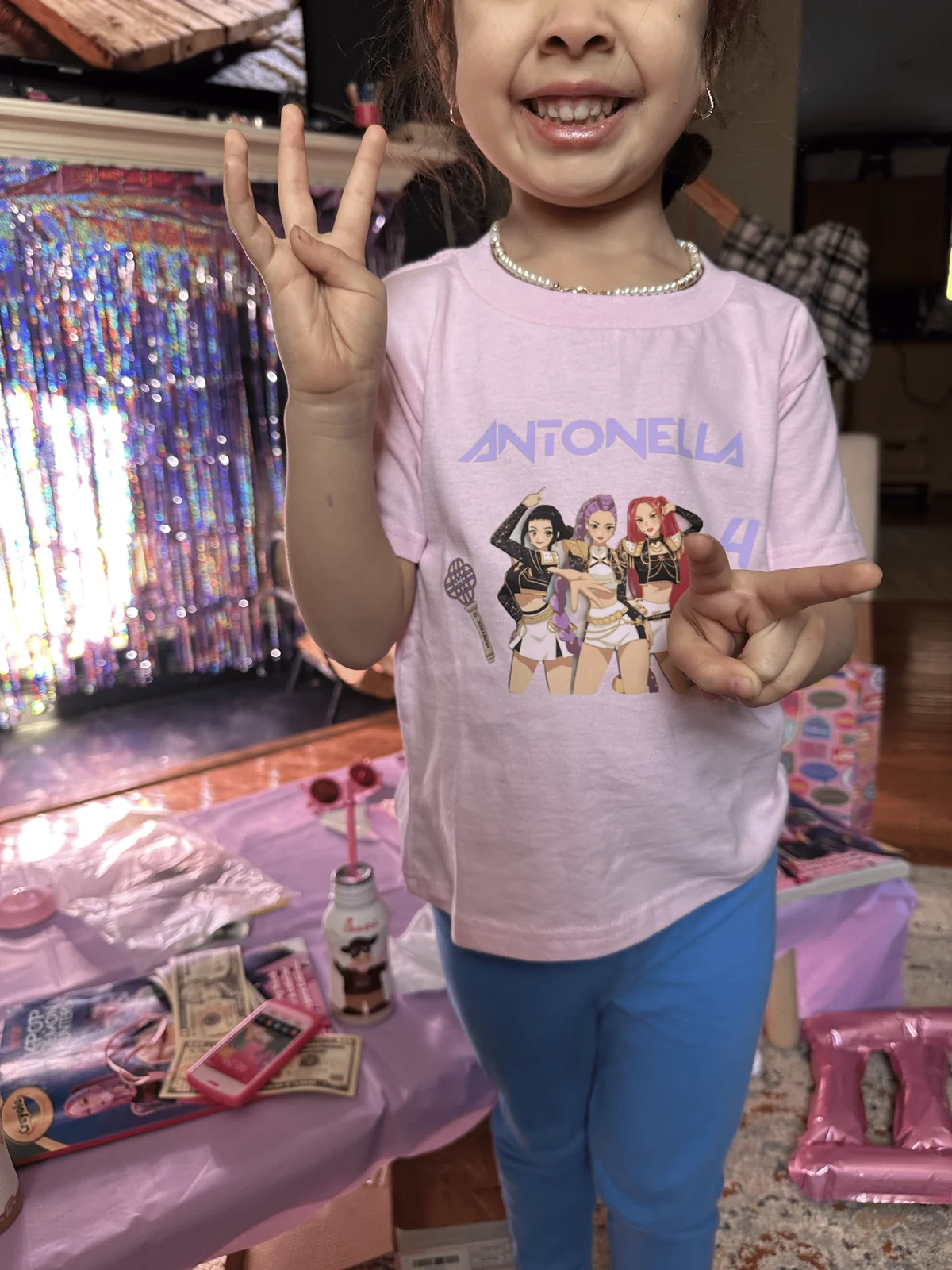 Birthday girl in custom-printed party favor t-shirt at pink pop star celebration