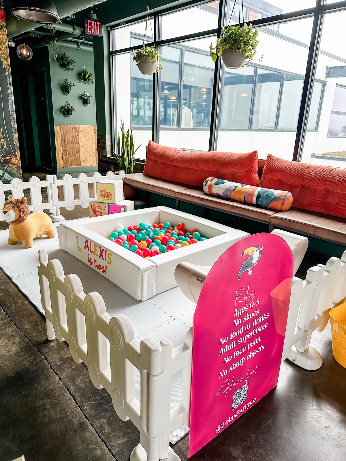Colorful soft play ball pit with tropical decor in an indoor venue