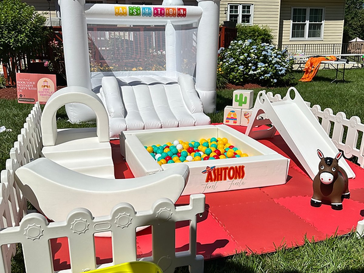 Full outdoor party setup with bounce house and red carpet