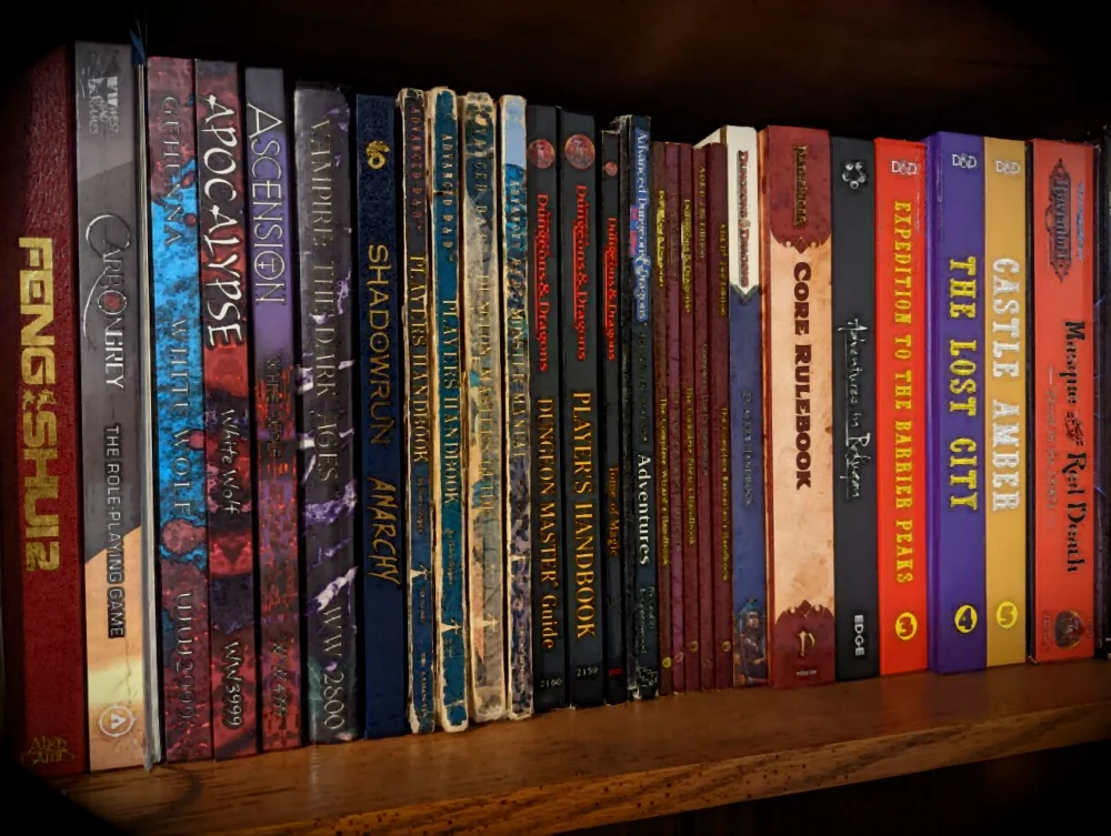 Collection of TTRPG books on a shelf. A mix of games from various generations including D&D, Feng Shui, and Shadowrun