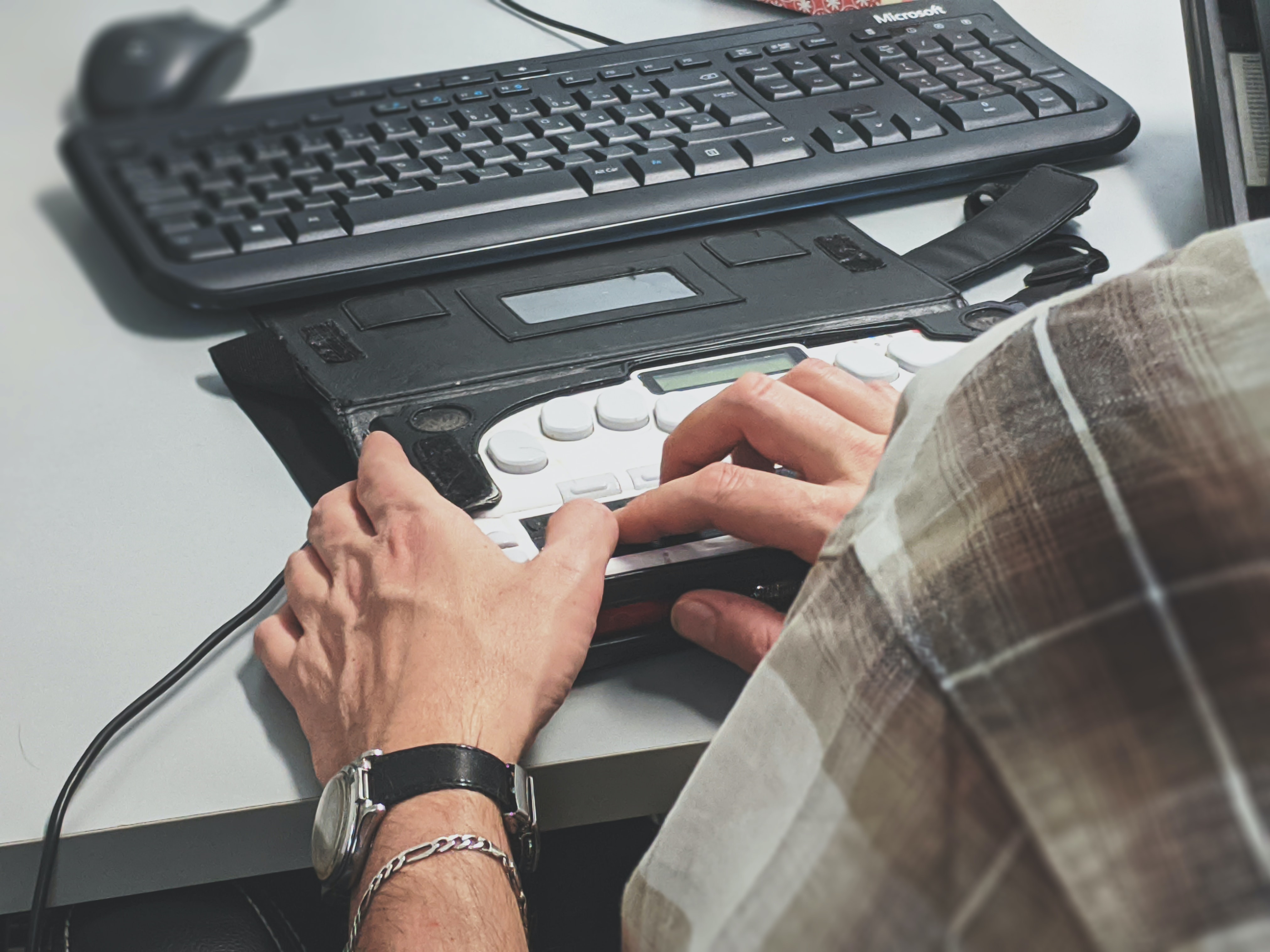 Photo of a person using a braille reader device on a desk by Sigmund from Unsplash