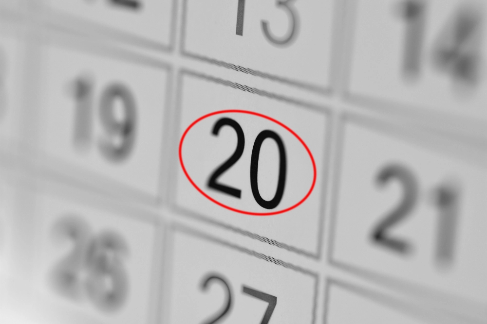 A close up of a section of a calendar. The 20 is clear and sharp with a red circle around it, while the rest of the numbers are blurred.