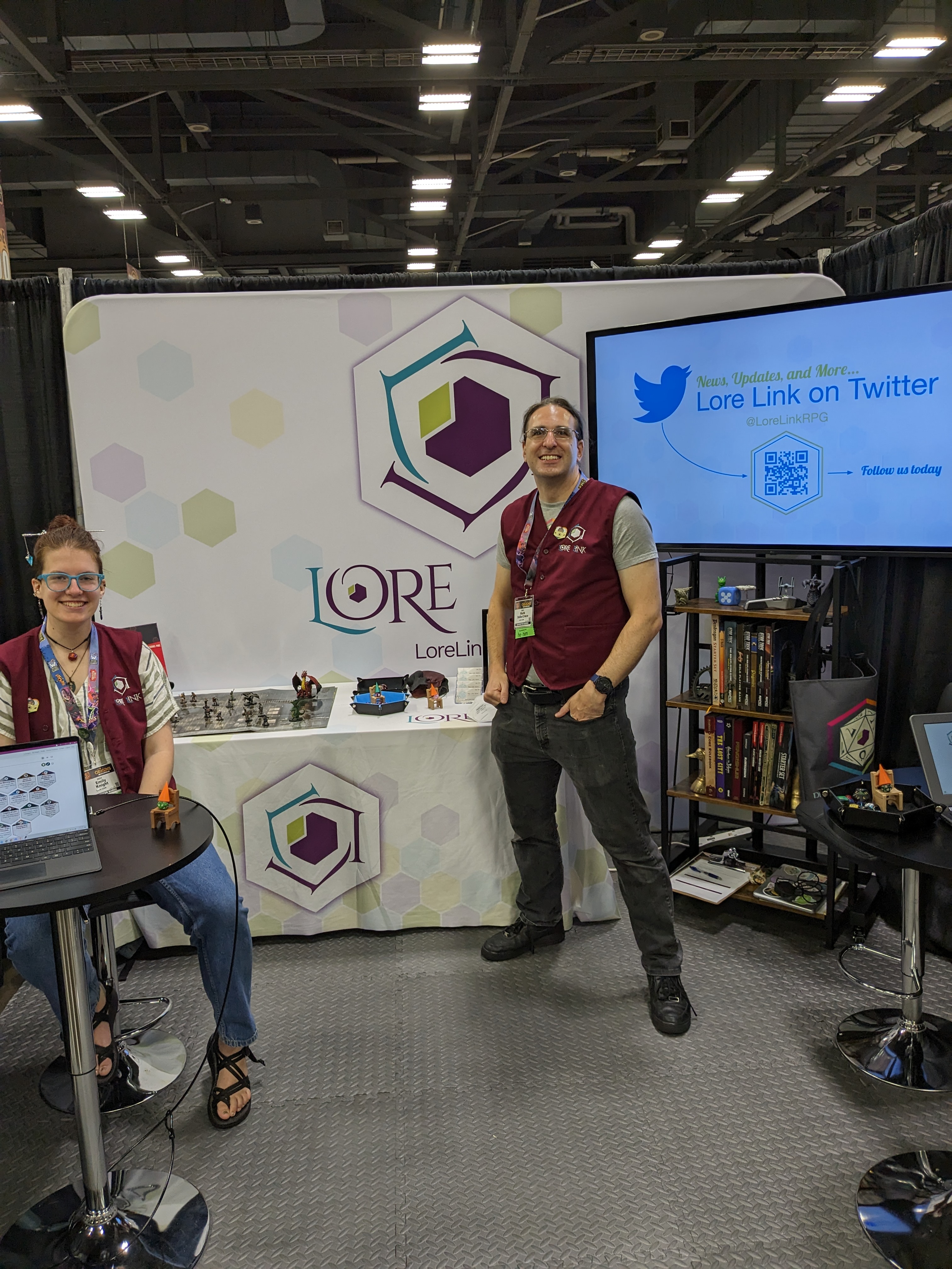 Emily and Mark, standing in the Lore Link booth at Origins, ready for a day of demoing and signing people up for the Kickstarter.