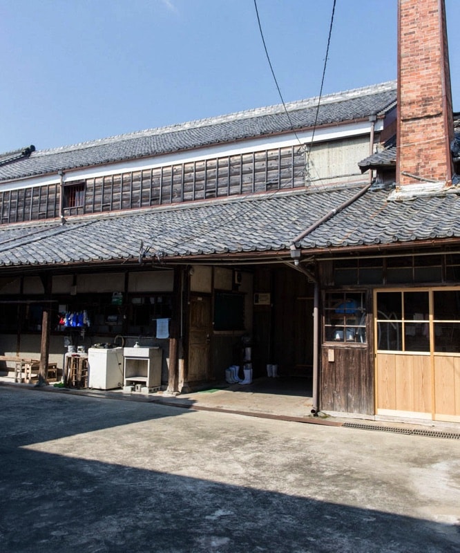 Exterior of the brewery's traditional tiled-roof storehouse with brick chimney