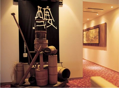Traditional sake-making tools displayed inside the brewery visitor area.