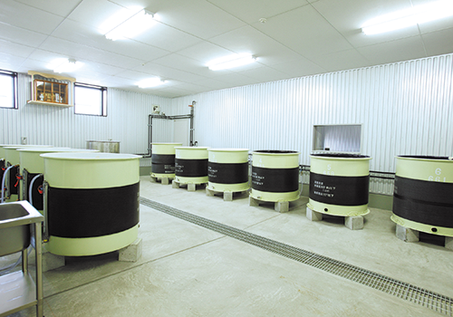 Fermentation tanks lined up inside the brewing facility.