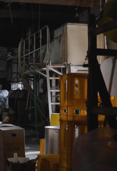 Storage area inside the brewery with crates and machinery.